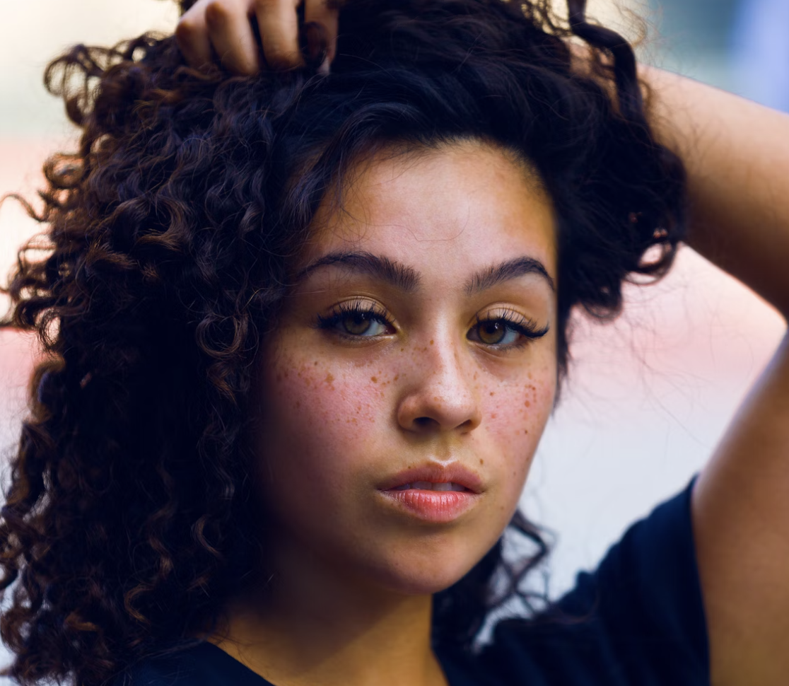 Curly haired woman touching hair